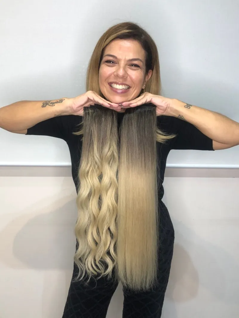 Lilian Sampaio segurando tiras de mega hair produzidas por ela